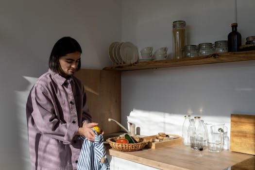 Personne préparant des légumes dans une cuisine minimaliste et lumineuse, avec des éléments zéro déchet.